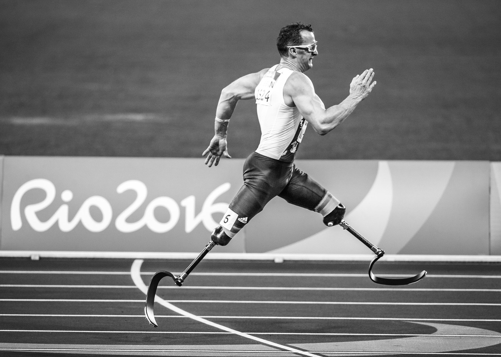 A runner on track with both limbs amputated knee down and running using prosthetic legs.